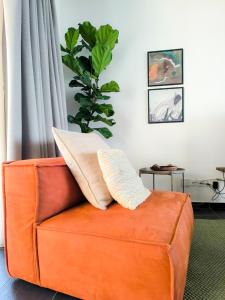 an orange couch in a living room with a plant at Bridge House 301-3BR Penthouse in Limassol +43 photos