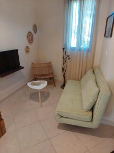 Una sala de estar con un sofá y un televisor. en Casa Cretese Chania, en Tsikalariá