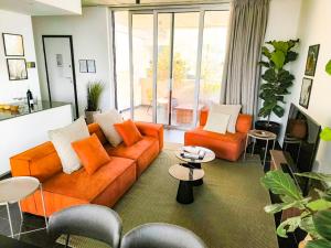 a living room with an orange couch and two chairs at Bridge House 301-3BR Penthouse in Limassol