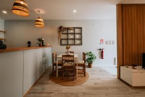 a kitchen with a table and chairs in a room at Maresia - Esmoriz Beach in Esmoriz