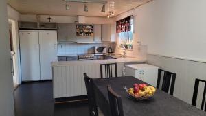 a kitchen with a table with a bowl of fruit on it at Österlän hus in Ystad