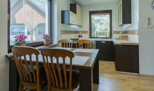 a kitchen with a wooden table and chairs in it at Dom Serwy in Serwy