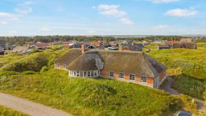 an old house with a thatched roof in a village at Thatched house with pool by the sea - SJ690 in Harboør