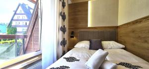 a small bed in a room with a window at VIP Apartamenty Centrum2 in Zakopane