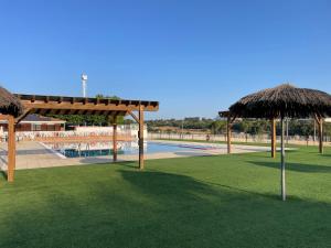 two straw umbrellas in front of a swimming pool at Cal Palaci in Caserras