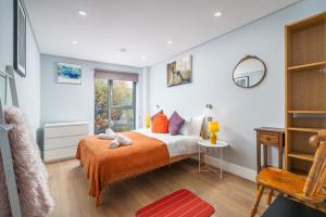 a bedroom with a bed with an orange blanket at Ultra Luxury Riverside Condo Central London Notting Hill with LIFT & Juliet balcony in London