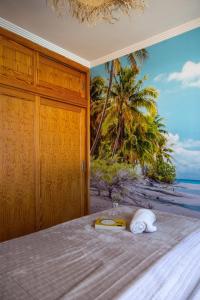 a room with a bed with a painting of a beach at Las Brisas Canary Home Rent in San Bartolomé de Tirajana +5 photos