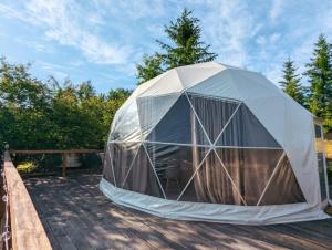 a dome tent sitting on a wooden deck at Glamping Ceahlau in Durău +4 photos