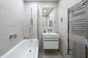 a white bathroom with a tub and a sink at Ultra Luxury Riverside Condo Central London Notting Hill with LIFT & Juliet balcony in London +59 photos