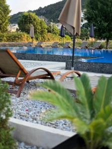 a pool with chairs and an umbrella and a swimming pool at Lula Apartments 2 in Ulcinj