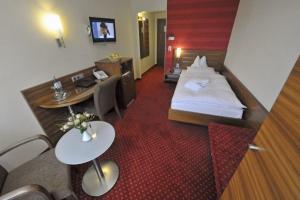 a hotel room with a bed and a desk at Hotel Nothnagel in Darmstadt
