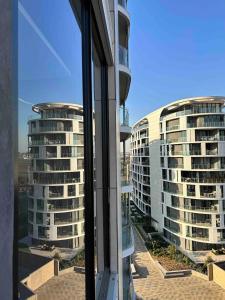 a view of two tall buildings from a window at Explore Ellipse - Emerald Studio in Midrand