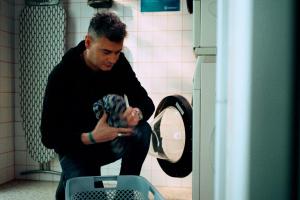 a man holding a dog in a toilet at MEININGER Hotel Bordeaux Gare Saint-Jean in Bordeaux