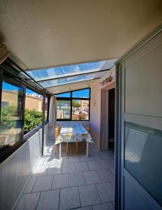 a patio with a table and chairs on a balcony at Appartement à 200m de la mer avec place de parking in Le Barcarès