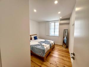 a small bedroom with a bed and a window at Amadeo Art&Stay Apartments in Amarante