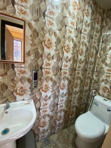 a bathroom with a sink and a toilet and a mirror at Newlives Transient 2 Hillside - 1st Floor in Baguio