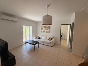a living room with a white couch and a table at Domaine la Yole Wine Resort in Vendres