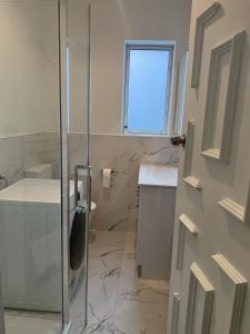a bathroom with a glass shower stall and a sink at Sun-kissed house in Auckland