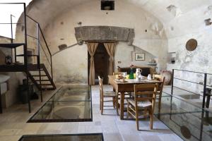 a dining room with a table and some stairs at Casa Nachiro - 16th Century Oil Mill Historic Dimora in Nardò