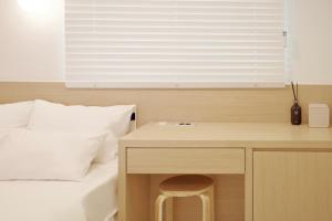 a bedroom with a bed with a desk next to a bed at Blue Note in Incheon +36 photos
