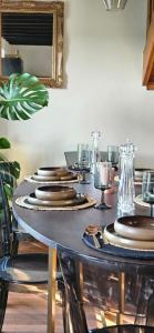 a table with plates and glasses on top of it at Chez Sam et Brice in Saint-Georges-Buttavent