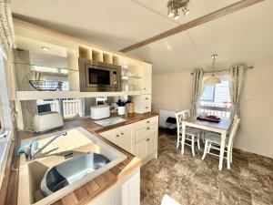 a kitchen with a sink and a table in it at North Bay Leisure Park in Bridlington