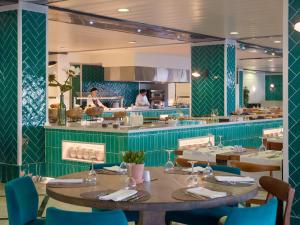 a restaurant with tables and chairs and a kitchen at H10 Cambrils Playa in Cambrils