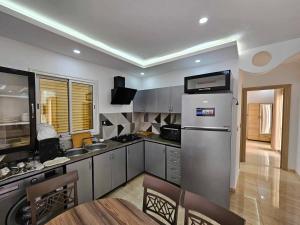 a kitchen with a refrigerator and a table in it at Villa vacances proximité plage in Taguermess