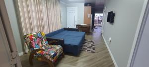 Una sala de estar con un sofá azul y dos sillas. en Residência familiar, en Erechim