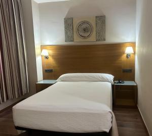 ein Hotelzimmer mit einem Bett und zwei Nachttischen in der Unterkunft Hotel Nova Roma in Merida + 2 Fotos