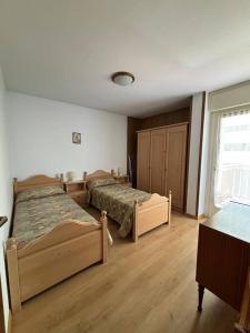 a bedroom with two beds and a window at Appartamenti Donatella in Cavalese +20 photos