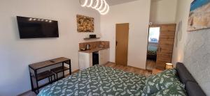 Un dormitorio con una cama, un escritorio y un televisor. en Marina Apartamenty, en Rozewie