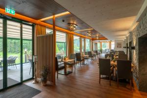 ein Restaurant mit Tischen, Stühlen und Fenstern in der Unterkunft Wanderhotel Taurerwirt in Kals am Großglockner