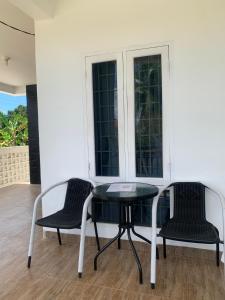 two chairs and a table in front of a window at Homestay Bunda Susi in Tanjungpati