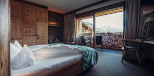 a hotel room with a bed and a large window at Jungbrunn Der Gutzeitort in Tannheim +63 photos