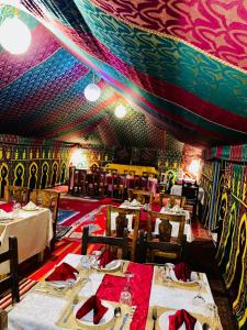 a dining room with tables and a colorful ceiling at lina safari luxury camp in Merzouga