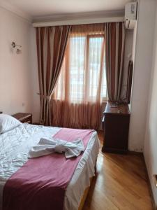 a bedroom with a bed with a robe on it at Terrace NANA in Tbilisi City