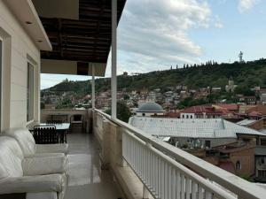 a balcony with chairs and a view of a city at Terrace NANA in Tbilisi City