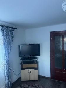 a living room with a tv and a blue wall at Casa Ovidiu in Pojorâta +16 photos