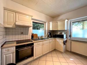 a kitchen with white cabinets and a sink and a window at Ferienhaus Harzseele in Elend +12 photos