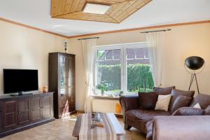 a living room with a couch and a tv at Ginas Ferienhaus in Nenndorf