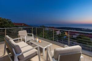 a balcony with chairs and a table with a view at Wellness Villa Biocrystal in Bakarac