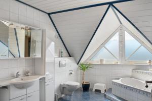 a bathroom with a window and a tub and a toilet at Ginas Ferienhaus in Nenndorf +21 photos