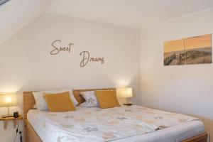 a bedroom with a bed with a sign on the wall at Ginas Ferienhaus in Nenndorf