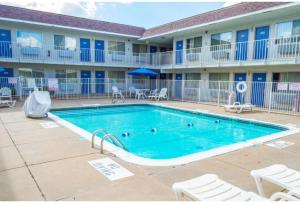 a swimming pool in front of a building with a hotel at Motel 6-Ardmore, OK in Ardmore