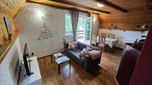 a living room with a blue couch and a table at MALA KUĆA, Lič in Lič
