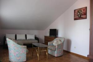 a living room with a couch and a table and chairs at Villa Velzon Guesthouse in Budva