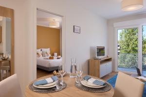une salle à manger avec une table et une chambre dans l'établissement Zenitude Hôtel-Résidences Saint-Paul-lès-Dax, à Saint-Paul-lès-Dax 13 autres photos