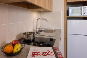 une cuisine avec un bol de fruits sur un comptoir dans l'établissement Zenitude Hôtel-Résidences Saint-Paul-lès-Dax, à Saint-Paul-lès-Dax