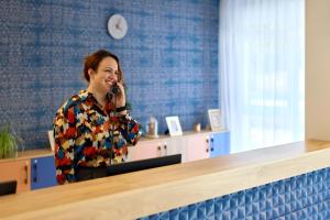 une femme qui parle sur un téléphone portable dans un bureau dans l'établissement Zenitude Hôtel-Résidences Saint-Paul-lès-Dax, à Saint-Paul-lès-Dax